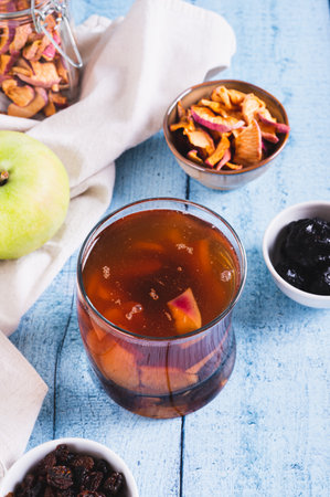 Sweet dried fruit compote in a glass on the table vertical viewの写真素材