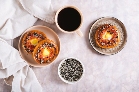 Baked bagels with tomato and quail egg on a plate on the table top viewの写真素材