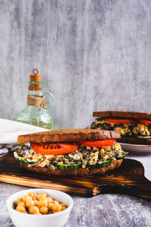 Vegetarian sandwich with seaweed, chickpeas, cucumber and tomato on grain bread vertical viewの写真素材