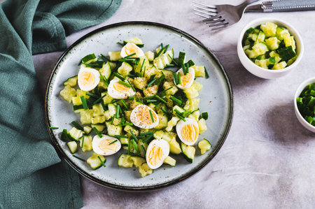 Appetizing mix of cucumbers, eggs and chives on a plate on the tableの写真素材