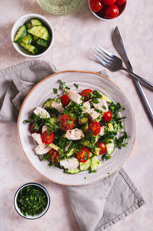 Fresh diet salad with chicken breast and vegetables on a plate on the table top and vertical viewの写真素材