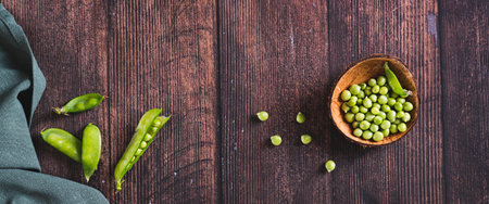 Bowl with green sugar peas on wooden table top view web bannerの写真素材