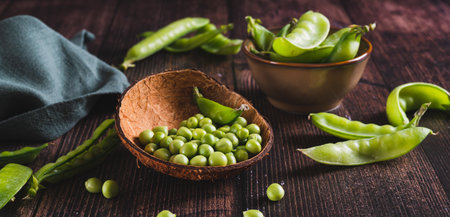 Fresh green peas in a bowl and in pods on the table web bannerの写真素材