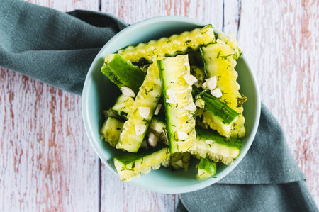 Close up of lightly salted cucumbers with dill and garlic in a bowl on the table top viewの写真素材