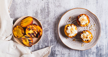 Grilled peaches with cottage cheese, nuts and honey on a plate top view web bannerの写真素材