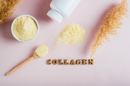 Collagen powder in a bowl and spoon and a glass of water on the table top viewの写真素材
