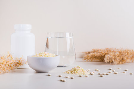 Peptide powder in a bowl and a glass of water on the tableの写真素材