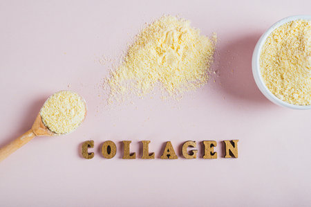 Close up of collagen powder in a bowl and spoon and a glass of water on the table top viewの写真素材