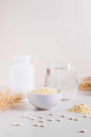 Peptide powder in a bowl and a glass of water on the table vertical viewの写真素材
