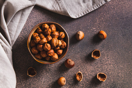 High-calorie peeled hazelnuts in a bowl on the table top viewの写真素材
