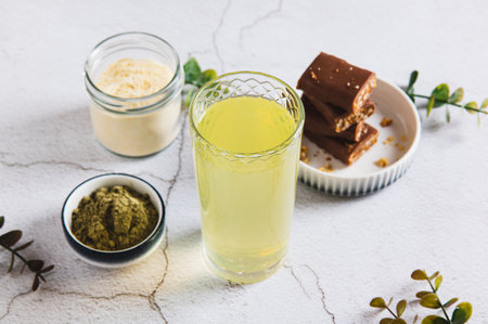 Matcha tea with protein powder in a glass and bars on the table