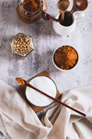 Miso-Spiked latte in a glass and a bowl of miso paste on the table top and vertical view