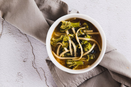 Close up of delicious miso soup with noodles and broccoli in a bowl on the table top viewの写真素材