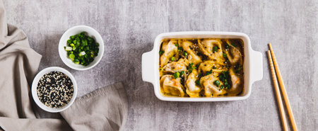 Dumpling Bake in coconut curry sauce with sesame seeds in a baking dish top view web bannerの写真素材