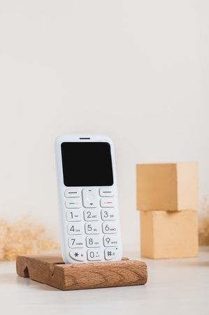 A retro push-button white telephone on a wooden stand on a table vertical viewの写真素材