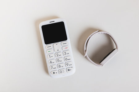 Close up of a retro push-button telephone and a fitness bracelet concept top viewの写真素材