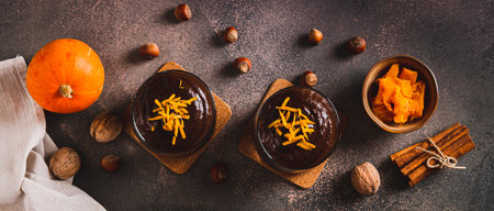 Autumn chocolate pumpkin dessert in glasses on the table top view web bannerの写真素材