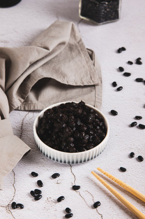 Asian fermented black beans on a plate on the table vertical view