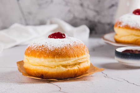 Delicious donuts in powdered sugar on parchment paper on the tableの写真素材