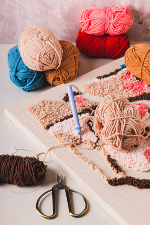 Punch needling kit, threads, canvas and needle for handmade crafts on the table vertical viewの写真素材