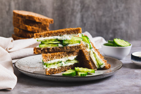 Cucumber sandwich with cream cheese on a plate on the tableの写真素材