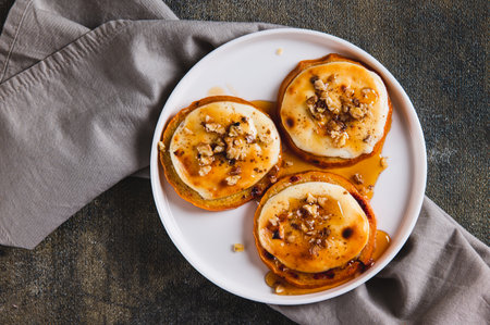 Close up of delicious baked persimmon with cottage cheese, nuts and honey on a plate top view