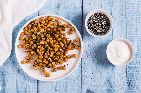 Delicious baked chickpeas with dill and sesame seeds on a plate on the table top viewの写真素材