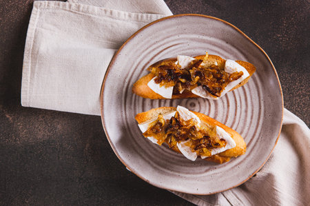 Close up of snack sandwiches with brie cheese and caramelized onions on a plate  top viewの写真素材
