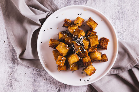Close up of fried tofu and sesame seeds on a plate on the table top viewの写真素材
