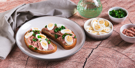 Delicious sandwiches on grain bread with tuna and quail egg on a plate on the table