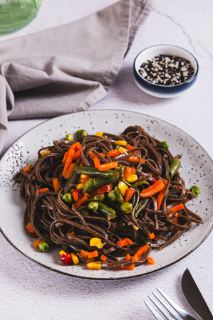 Buckwheat soba noodles with vegetables on a plate on the table vertical view