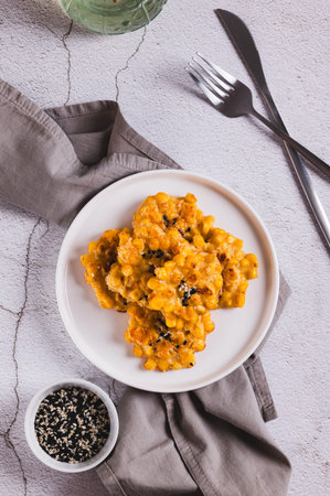 Golden crispy corn fritters on a plate on the table top and vertical viewの写真素材