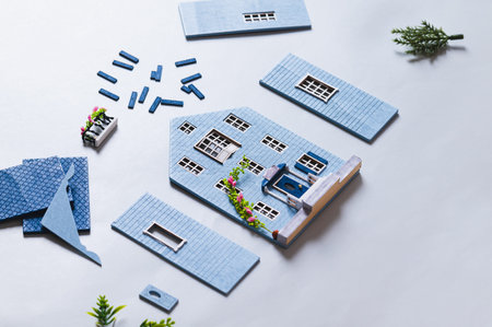 Details for assembling a miniature house model on a blue background