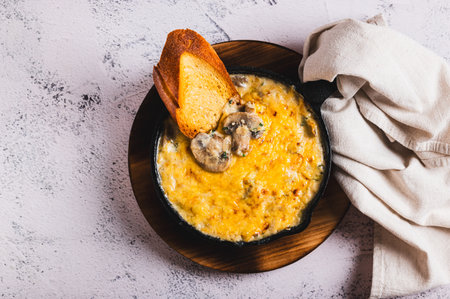 Close up of delicious julienne with mushrooms and cheese in a frying pan on the table top view