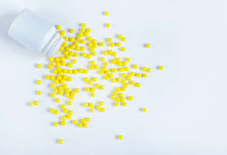 Round yellow vitamin C tablets on a white background.の写真素材