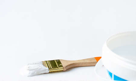 Bank paints and brush in white paint on a wooden background.の写真素材