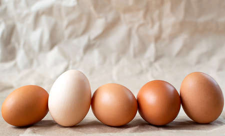 Five eggs on a craft paper background.