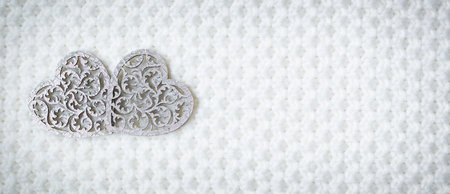 Two wooden hearts symbol of love on white fur background, Saint Valentine Day concept.