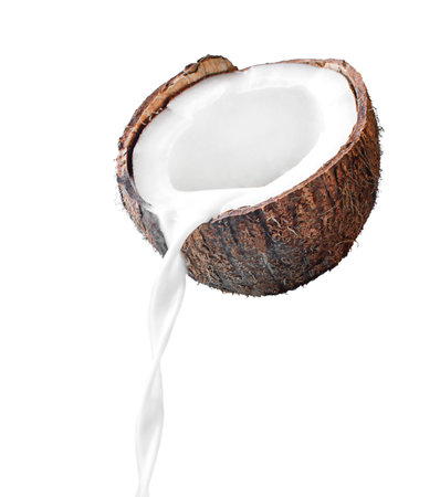 Coconut milk pouring out of coconut fruit isolated on white background