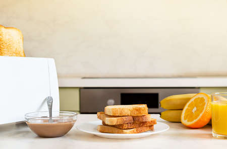 Served table for breakfast with toast, fruit, orange juice, peanut paste.
