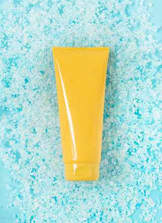 yellow tube of sunscreen on sea blue salt.の写真素材
