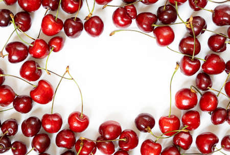 lots of fresh red cherries on a white background. summer background with space for text.の写真素材