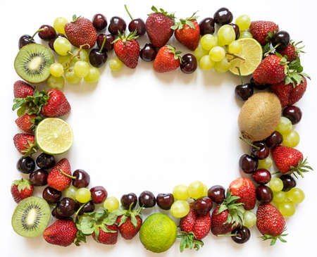 frame from juicy fruits with copy space. strawberries, cherries, kiwi and grapes on a white...