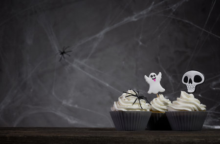scary halloween cupcakes on a dark background with cobwebs.の写真素材