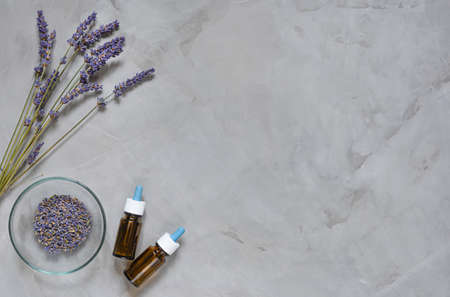 Alternative medicine herbs of lavender and oil on grey backgroundの写真素材