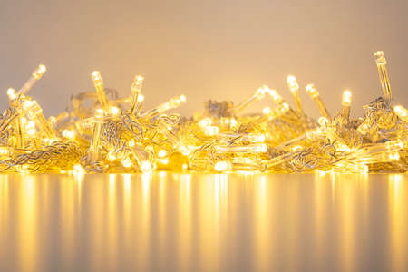 golden garland of warm white lights on a table with reflection.の写真素材
