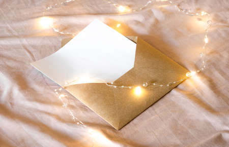 envelope with a letter lies on the bed along with a Christmas garland.の写真素材