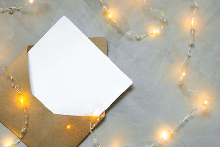 envelope with a letter lies on gray backgroun with a Christmas garland.の写真素材