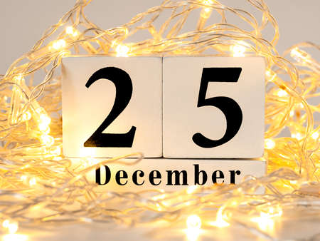 December 25th on wooden calendar and golden garland.