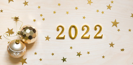 Christmas decorations and numerals 2022 on wooden background.